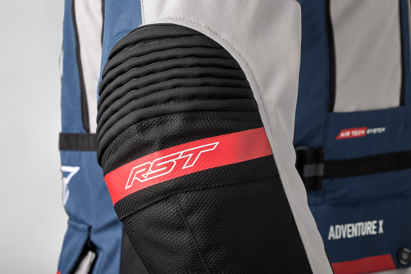 Detalj av ärmen på RST Textil Mc-Jacka Adventure-X med röd RST-logotyp och förstärkt material.